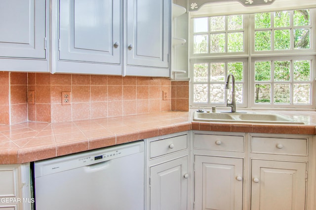 6041 Torrey Pines Dr, El Paso, TX 79912 - kitchen featuring backsplash, white cabinets, white dishwasher, and a sink