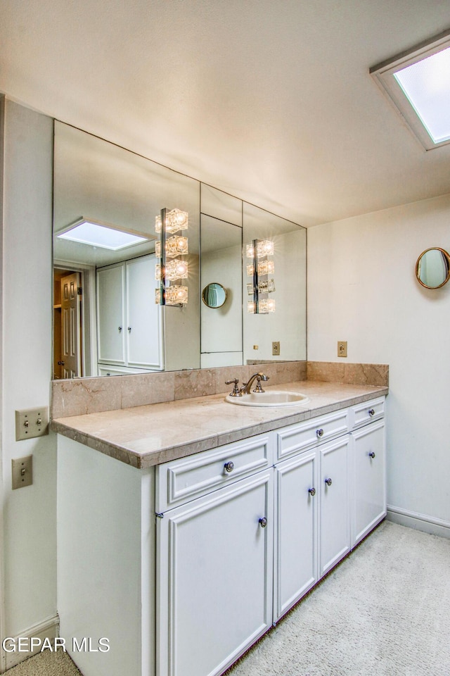 6041 Torrey Pines Dr, El Paso, TX 79912 - bathroom with vanity, baseboards, and a skylight
