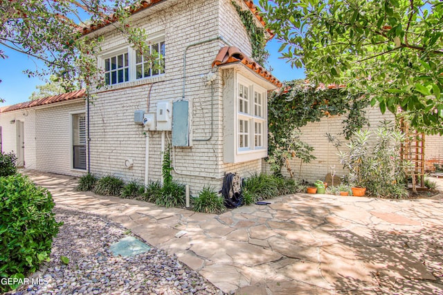6041 Torrey Pines Dr, El Paso, TX 79912 - view of side of home featuring a patio and brick siding