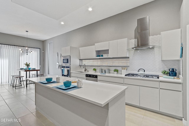 1725 Eased St, El Paso, TX 79928 - kitchen with wall chimney range hood, a sink, appliances with stainless steel finishes, light countertops, and a kitchen island