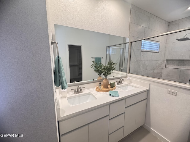1725 Eased St, El Paso, TX 79928 - bathroom with double vanity, a textured wall, a tile shower, and a sink