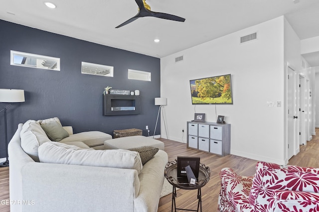 living room with visible vents, recessed lighting, and an accent wall