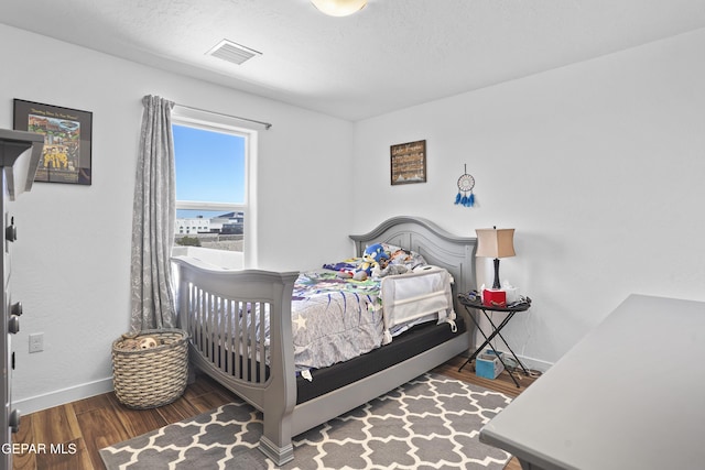 bedroom featuring visible vents, wood finished floors, and baseboards