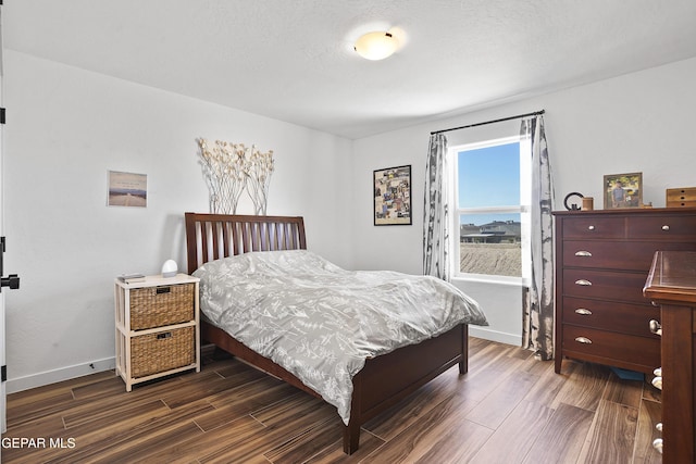 bedroom with baseboards and dark wood finished floors