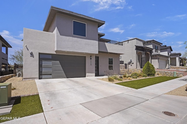 contemporary house with stucco siding, concrete driveway, and an attached garage