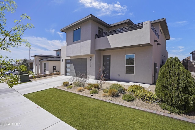contemporary house featuring a front lawn, a garage, a balcony, concrete driveway, and stucco siding