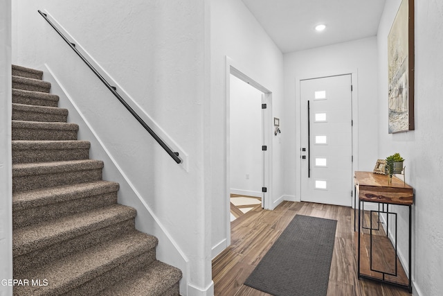 entryway featuring recessed lighting, stairs, wood finished floors, and baseboards