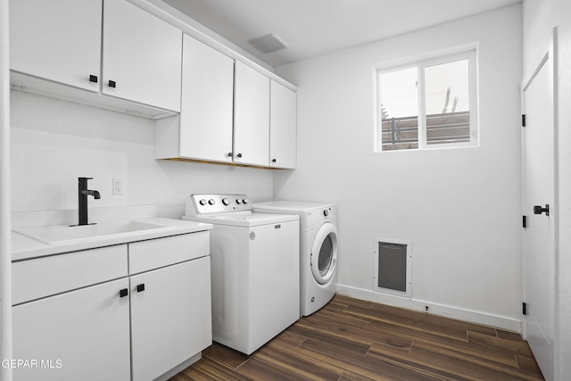 laundry room with independent washer and dryer, a sink, baseboards, cabinet space, and dark wood finished floors