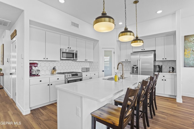 kitchen with visible vents, stainless steel appliances, dark wood-type flooring, and a sink
