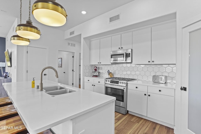 kitchen featuring visible vents, stainless steel appliances, and a sink