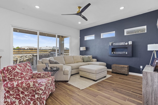 living area featuring wood finished floors, ceiling fan, recessed lighting, and baseboards