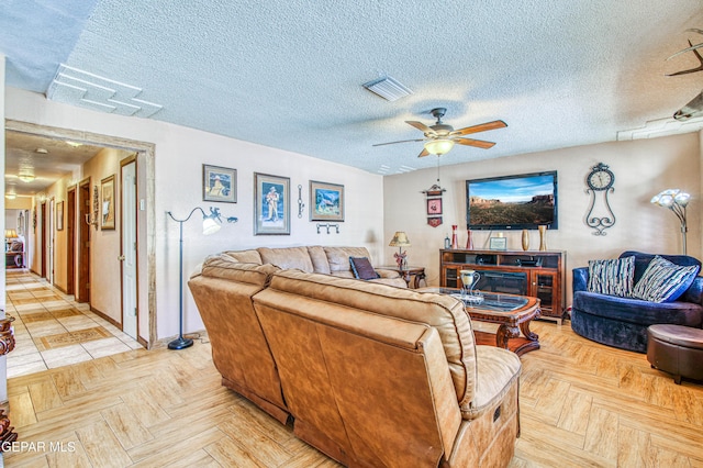 916 Mike Maros St, Fabens, TX 79838 - living room with visible vents, ceiling fan, and a textured ceiling