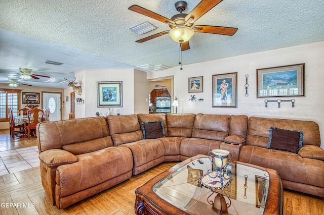 916 Mike Maros St, Fabens, TX 79838 - living area featuring a textured ceiling, ceiling fan, and visible vents