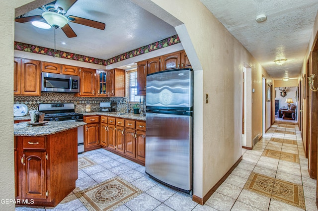 916 Mike Maros St, Fabens, TX 79838 - kitchen featuring appliances with stainless steel finishes, a textured ceiling, a textured wall, and a ceiling fan