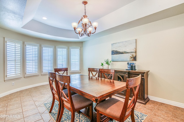 dining room featuring an inviting chandelier, baseboards, recessed lighting, and a raised ceiling