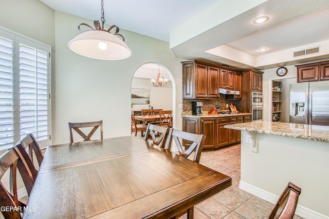 dining room with visible vents, an inviting chandelier, recessed lighting, arched walkways, and light tile patterned floors