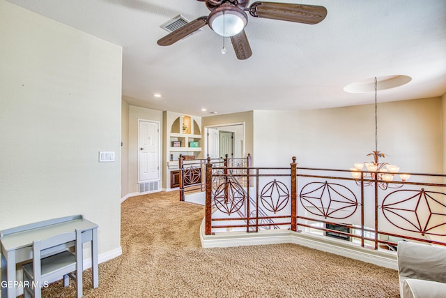 hall with a chandelier, carpet, baseboards, an upstairs landing, and visible vents