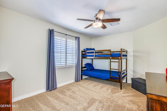 carpeted bedroom featuring baseboards and a ceiling fan