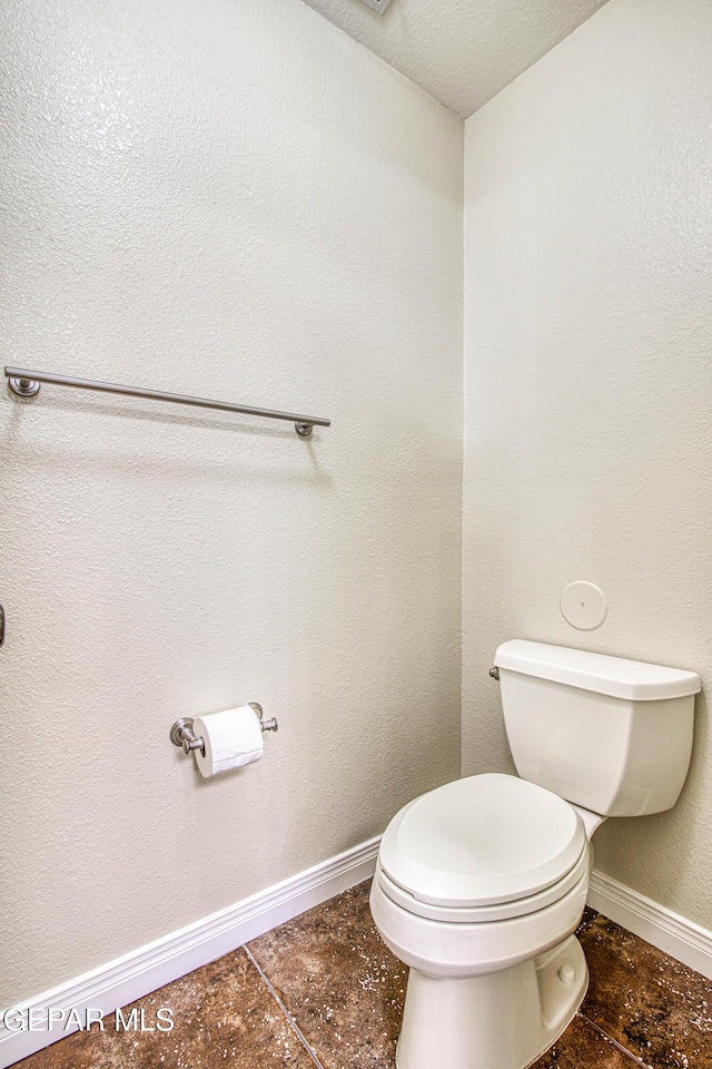 bathroom with toilet and baseboards