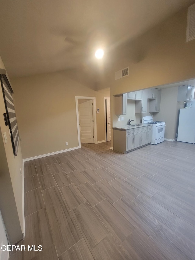 11531 Ernest Rd, Socorro, TX 79927 - unfurnished living room with vaulted ceiling, a sink, baseboards, and wood tiled floors