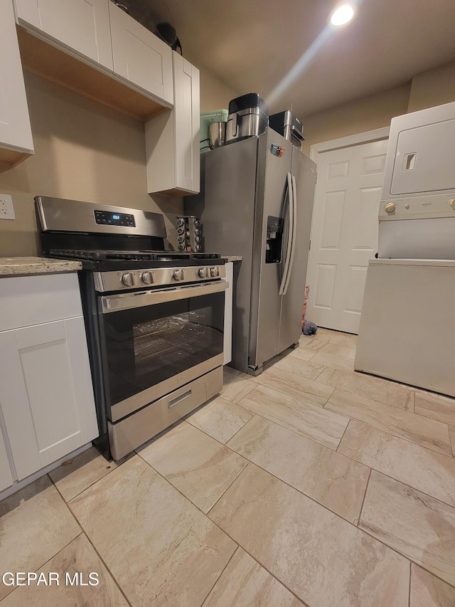11531 Ernest Rd, Socorro, TX 79927 - kitchen with appliances with stainless steel finishes, stacked washing machine and dryer, white cabinetry, and recessed lighting