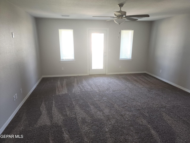 carpeted spare room featuring a ceiling fan, baseboards, and visible vents