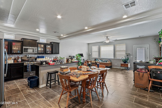 dining area with recessed lighting, a textured ceiling, visible vents, and ceiling fan