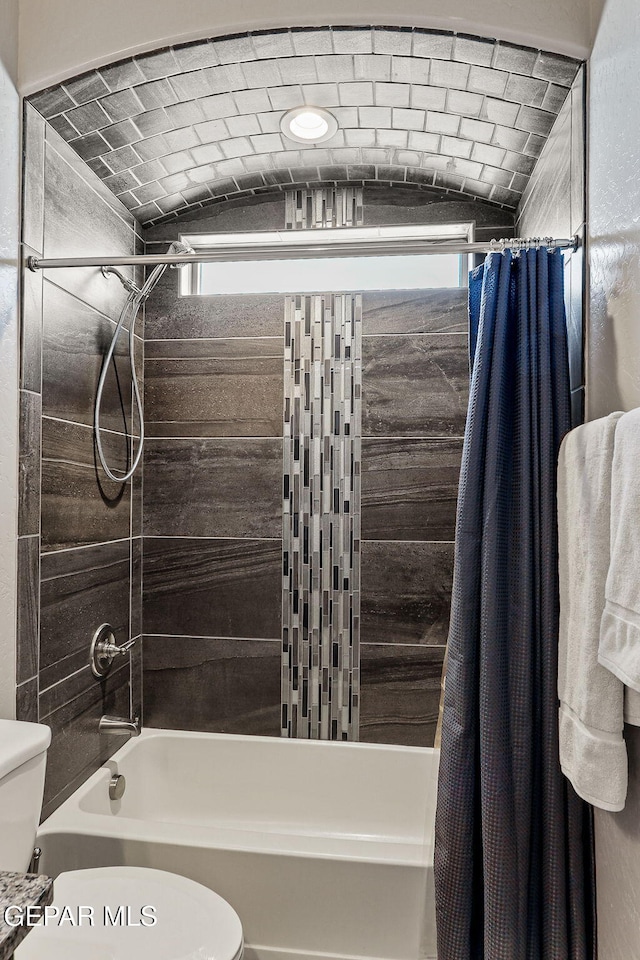 bathroom featuring shower / bath combination with curtain and toilet
