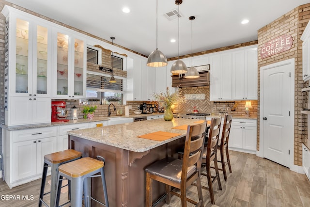 kitchen featuring a center island, light wood-style flooring, and white cabinetry