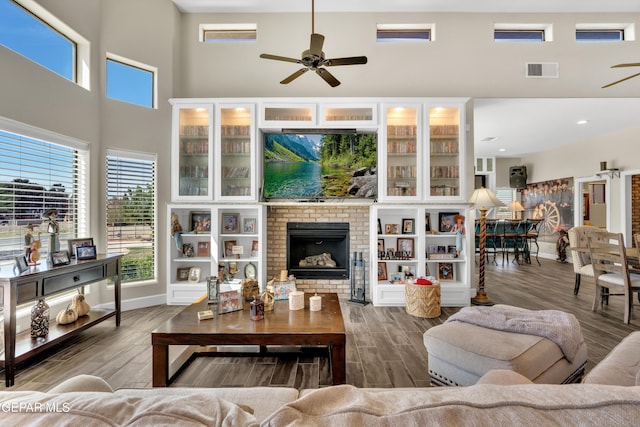 living area featuring visible vents, ceiling fan, and a towering ceiling