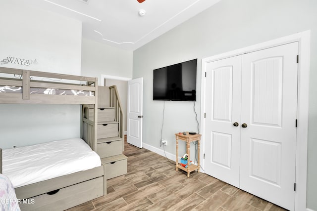 bedroom with light wood-style floors, baseboards, and a closet