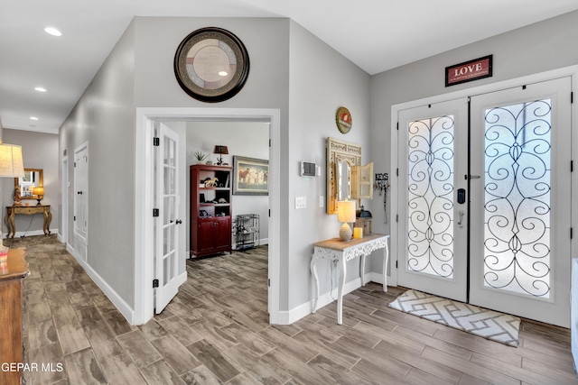 foyer entrance with recessed lighting, wood finished floors, french doors, and baseboards