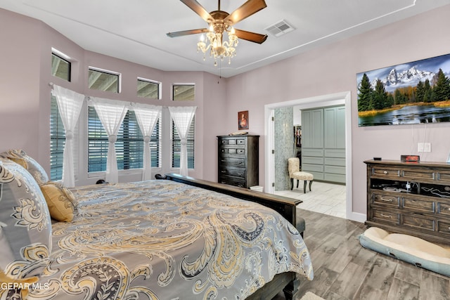 bedroom featuring a ceiling fan, visible vents, wood finished floors, and baseboards