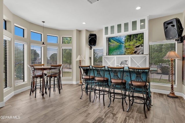 bar with recessed lighting, a dry bar, wood finished floors, and baseboards