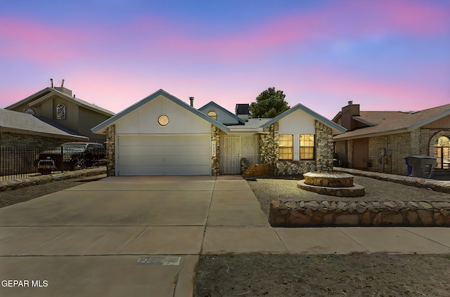 ranch-style house with concrete driveway, stone siding, and a garage