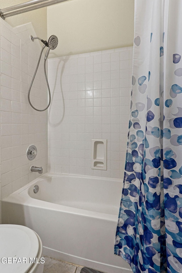 bathroom featuring tile patterned flooring, toilet, and shower / bathtub combination with curtain