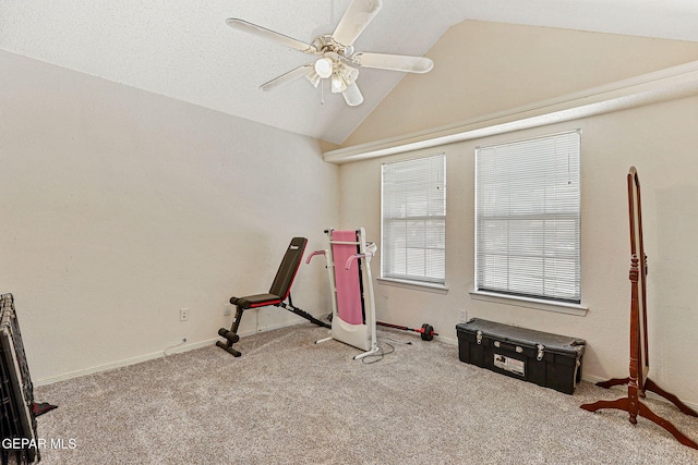interior space with baseboards, a ceiling fan, vaulted ceiling, and carpet flooring