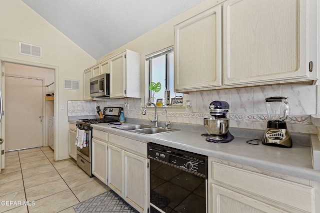 kitchen with visible vents, tasteful backsplash, a sink, vaulted ceiling, and stainless steel appliances