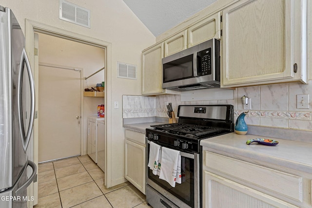 kitchen with vaulted ceiling, light countertops, stainless steel appliances, and visible vents