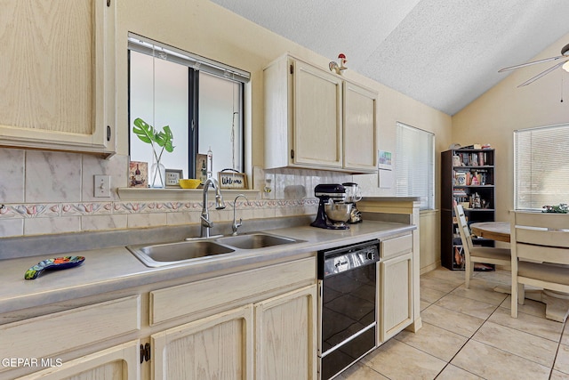 kitchen with a textured ceiling, vaulted ceiling, a sink, light tile patterned floors, and black dishwasher