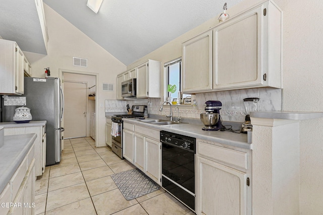 kitchen featuring visible vents, lofted ceiling, light tile patterned flooring, a sink, and stainless steel appliances