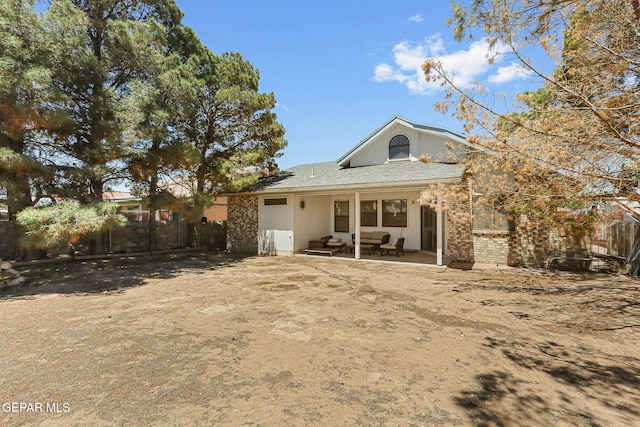 rear view of property featuring a patio and fence