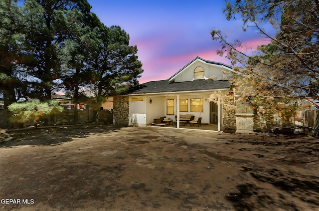 back of property at dusk with a patio area