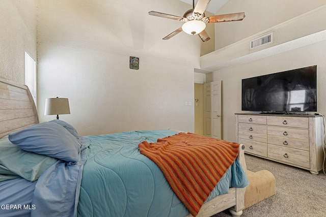 bedroom featuring a high ceiling, light carpet, a ceiling fan, and visible vents