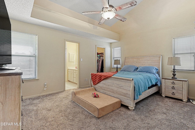 bedroom featuring a closet, baseboards, connected bathroom, a spacious closet, and carpet