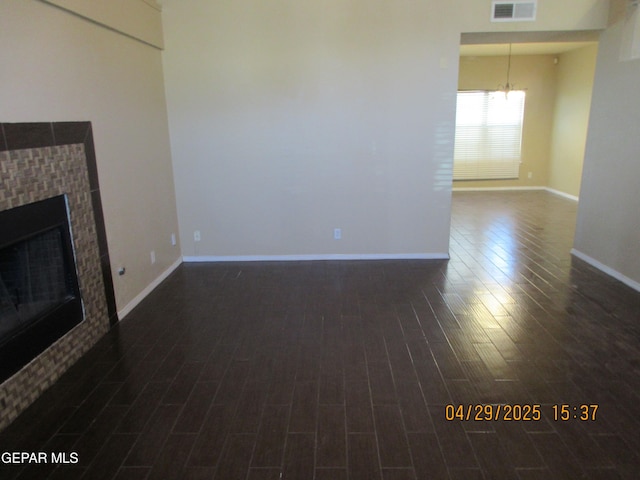 11233 Red Barrel Pl, El Paso, TX 79934 - unfurnished living room with a fireplace, a chandelier, dark wood finished floors, baseboards, and visible vents