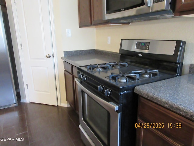 11233 Red Barrel Pl, El Paso, TX 79934 - kitchen featuring dark tile patterned floors, baseboards, appliances with stainless steel finishes, and dark countertops