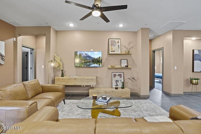 living area featuring visible vents, ceiling fan, tile patterned floors, and baseboards