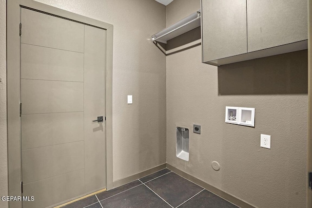 laundry area featuring hookup for a washing machine, dark tile patterned flooring, electric dryer hookup, cabinet space, and gas dryer hookup