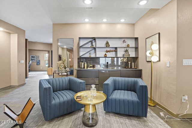 sitting room with wet bar and baseboards